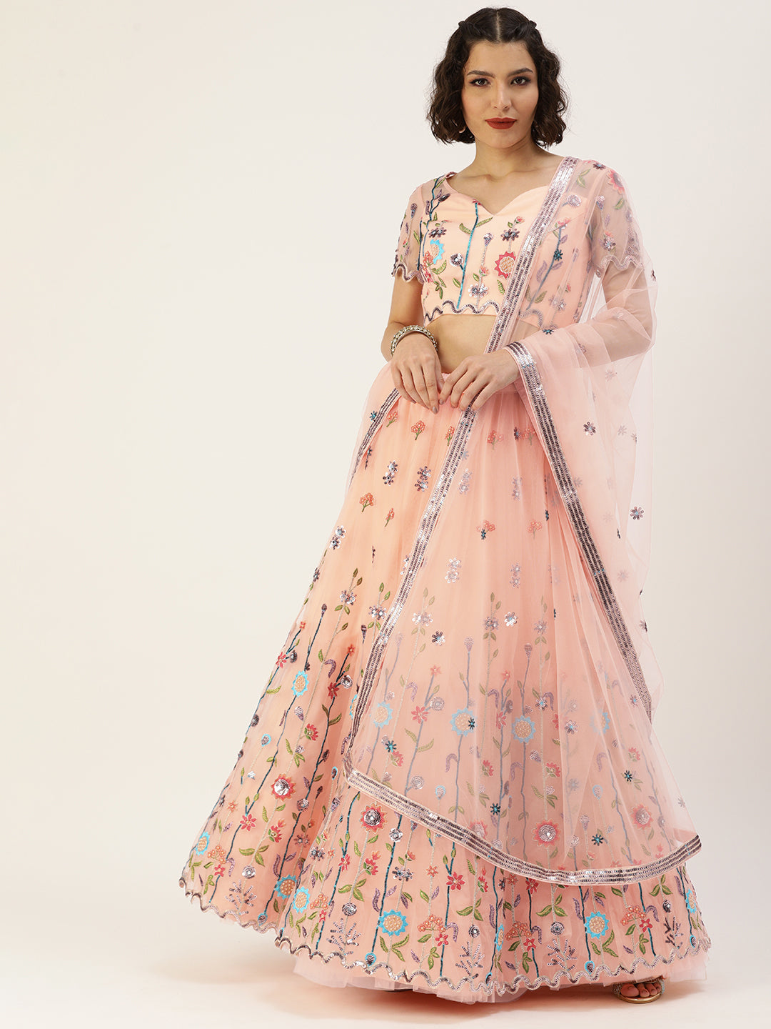 Photo of A bride in a white lehenga with floral embroidery with a peach  dupatta